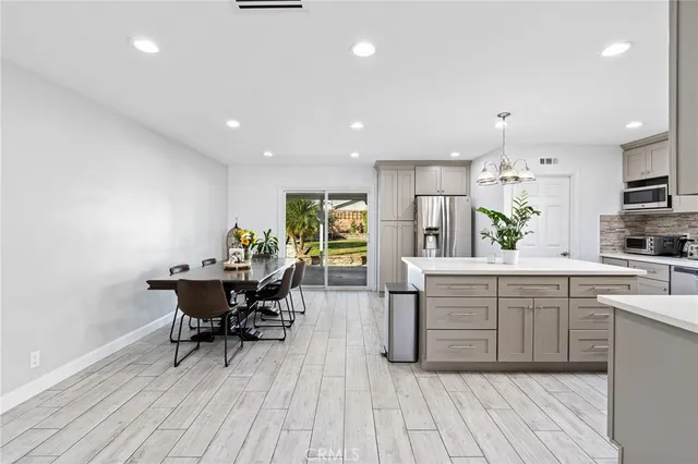 a kitchen with cabinets table and chairs
