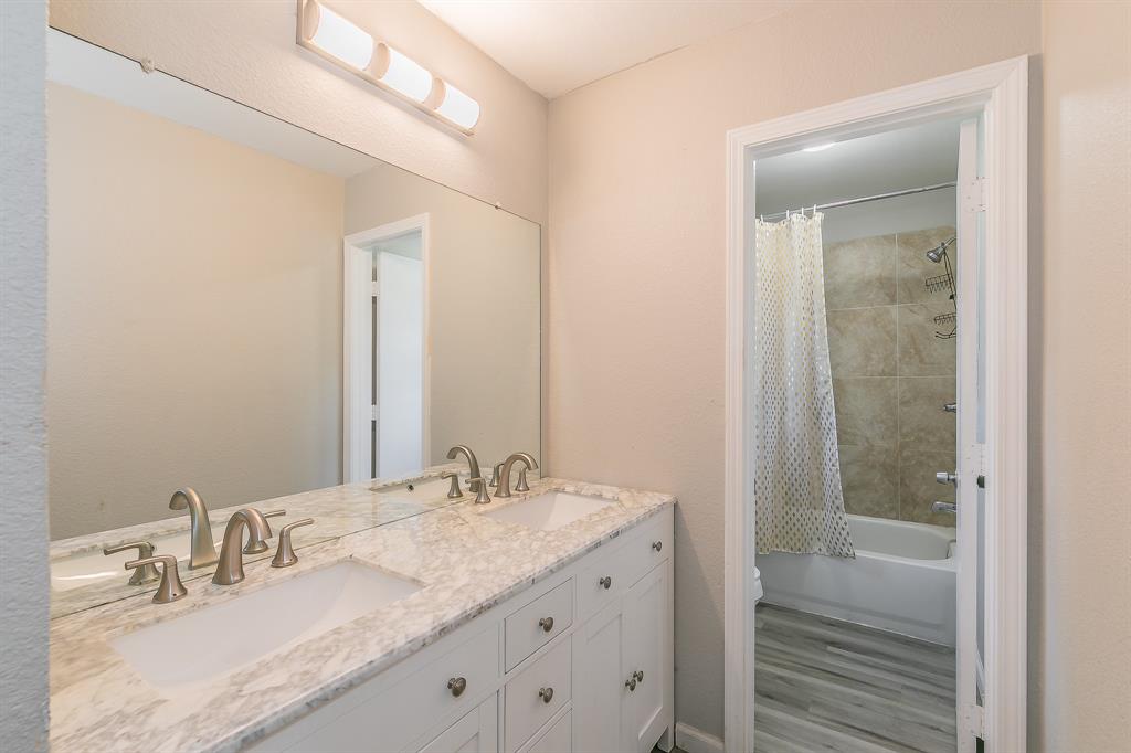 3025 David Drive Rowlett, TX 75088 - Photo 16 of 23 Bathroom with double vanity, shower / tub combo, and wood finished floors