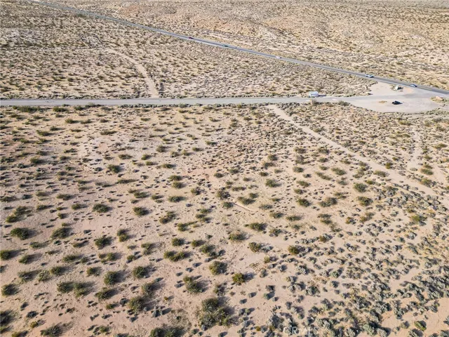 an aerial view of house with yard and mountain view in back