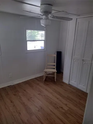 a view of a livingroom with wooden floor and a window