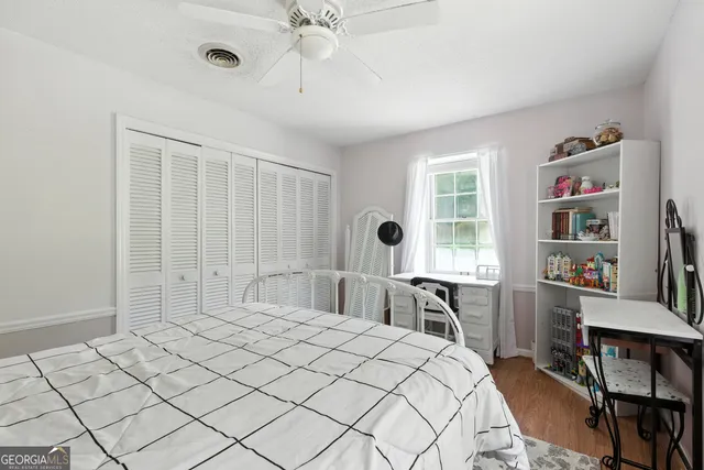 a bedroom with a large bed and a book shelf