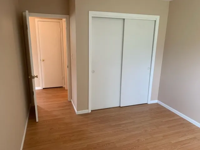 a view of a room with wooden floor and a hallway