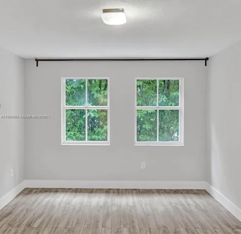 a living room with furniture a clock and a large window