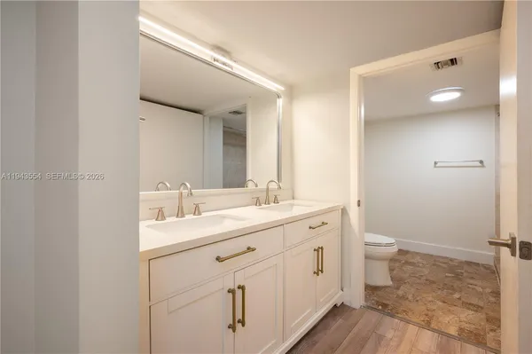 a bathroom with a sink a toilet and a mirror
