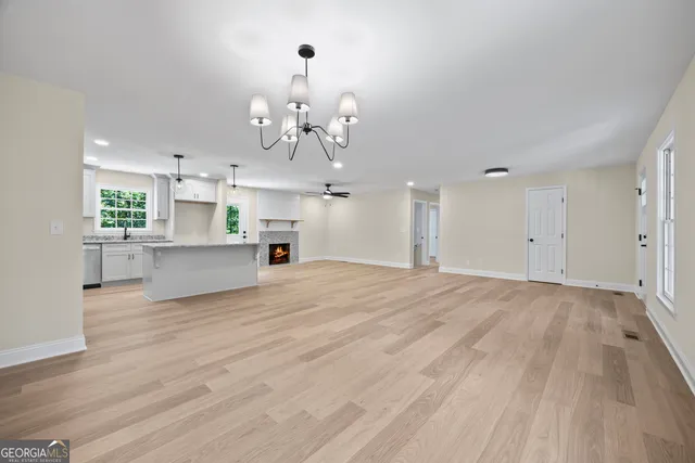 a kitchen with stainless steel appliances granite countertop a refrigerator a stove a sink dishwasher and a refrigerator with wooden floor