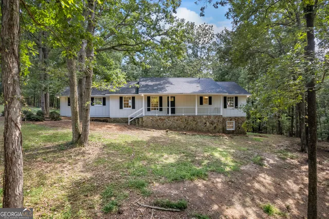 a view of a house with backyard and trees