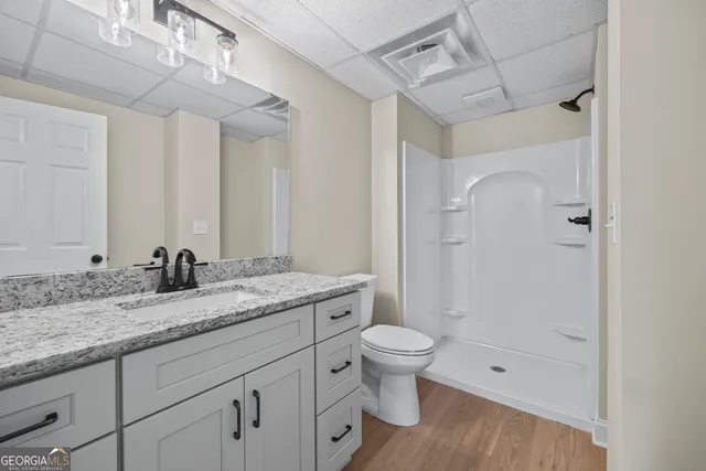 a bathroom with a granite countertop toilet sink and mirror