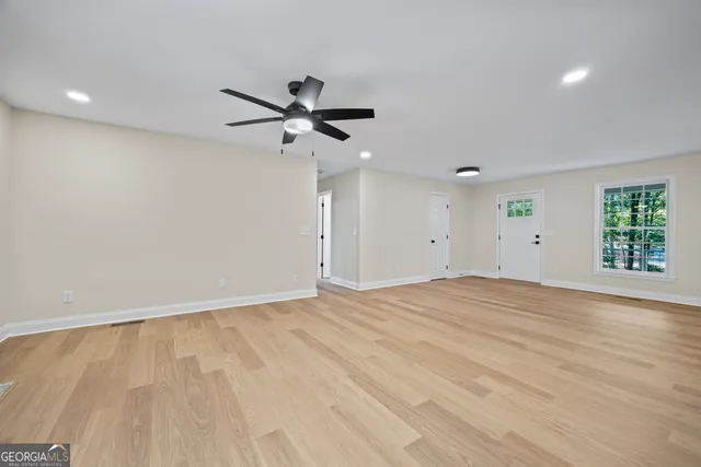a view of kitchen with stainless steel appliances kitchen island a refrigerator sink and white cabinets