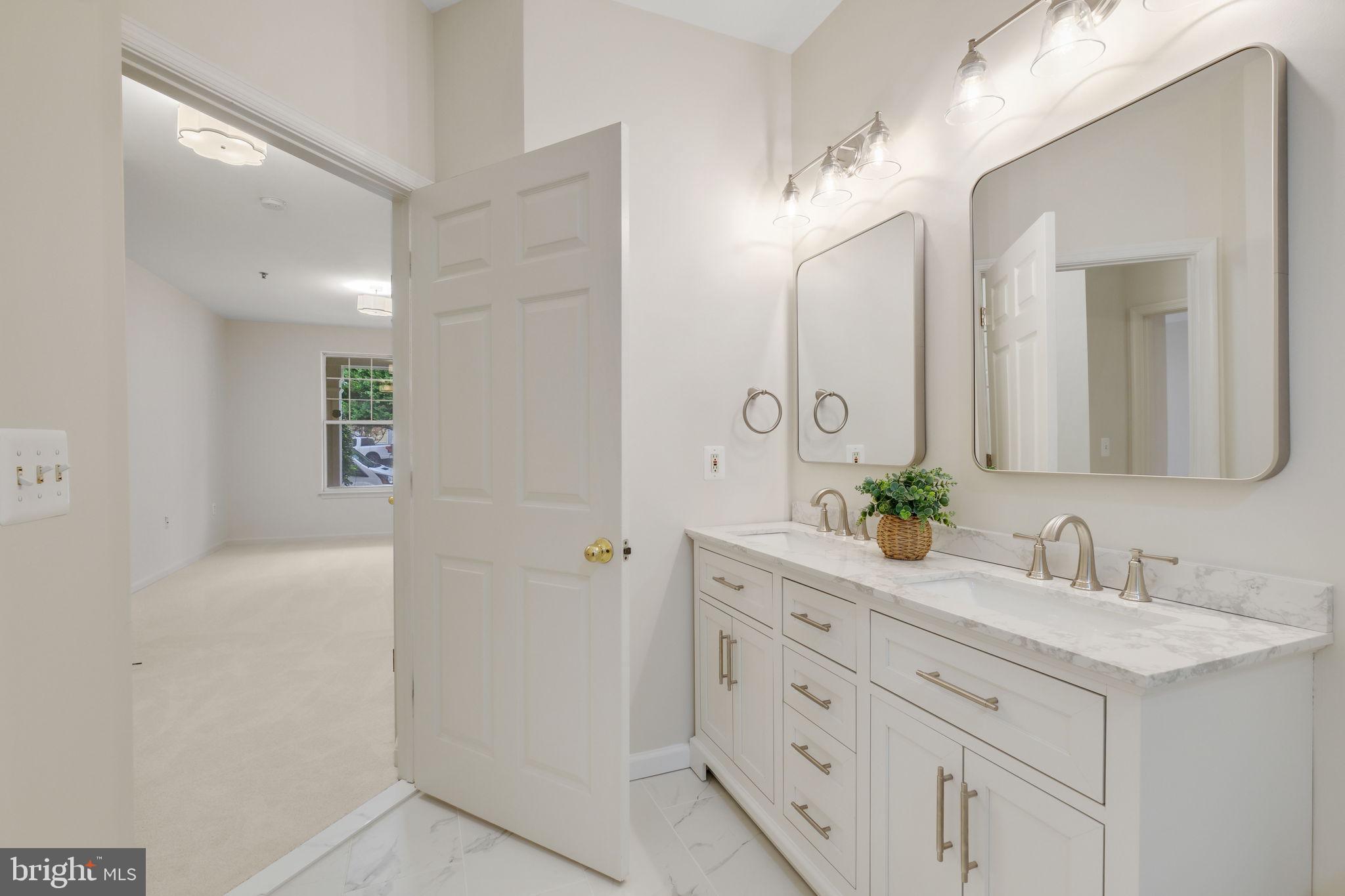 150 Chevy Chase Street, Unit 102 Gaithersburg, MD 20878 - Photo 16 of 41 a bathroom with a double vanity sink and a mirror