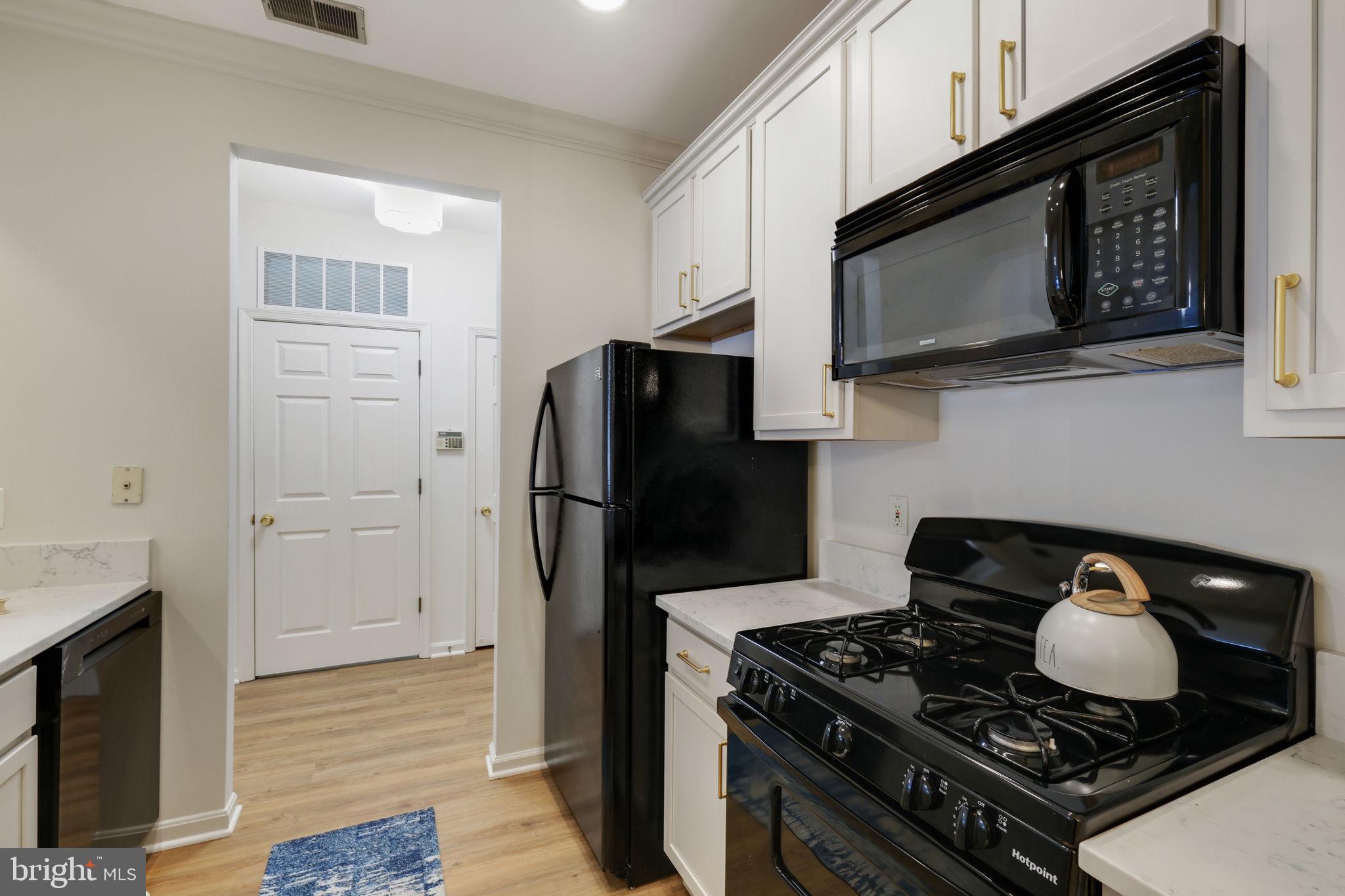 150 Chevy Chase Street, Unit 102 Gaithersburg, MD 20878 - Photo 3 of 41 a kitchen with a stove and a microwave