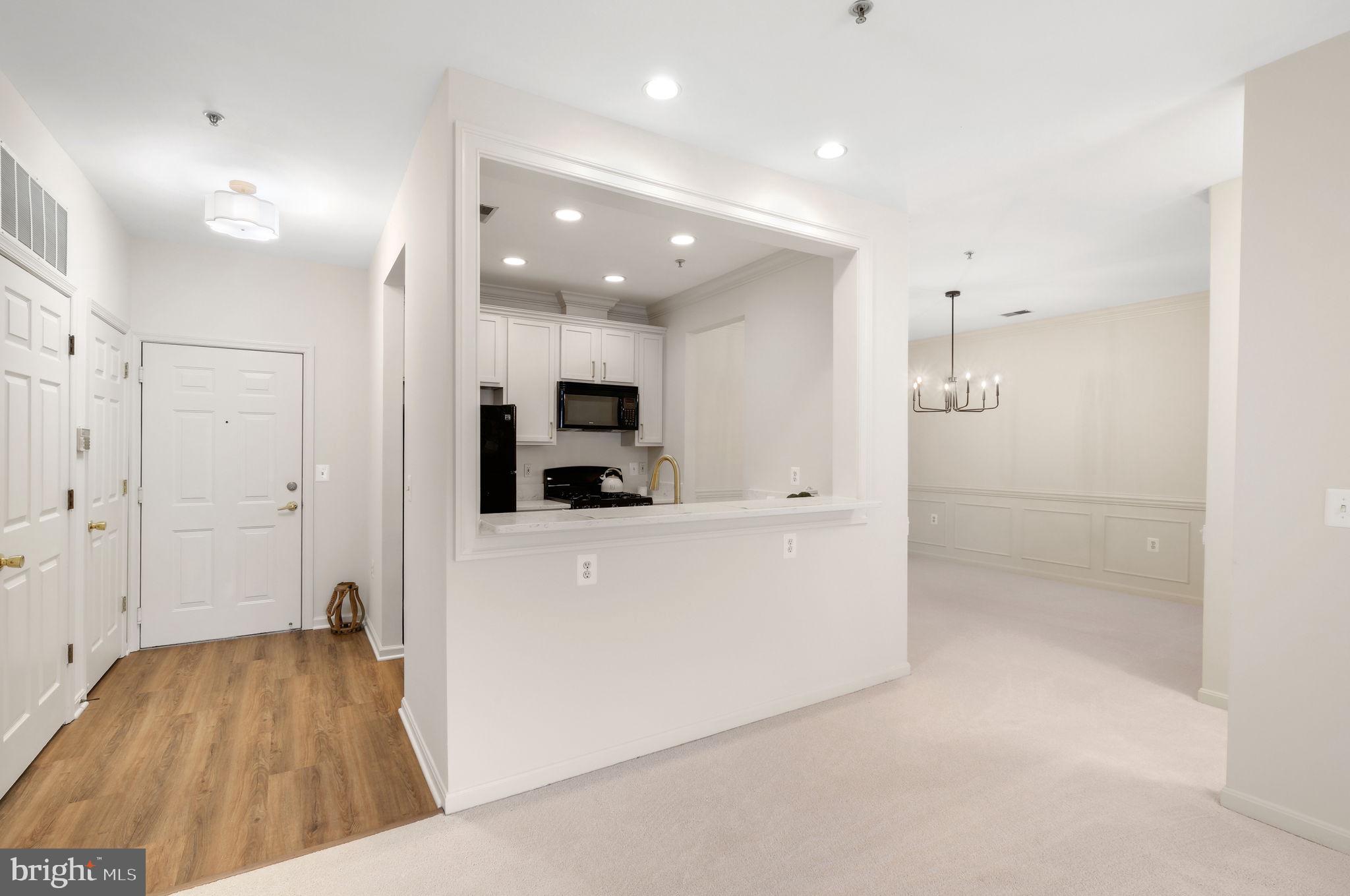150 Chevy Chase Street, Unit 102 Gaithersburg, MD 20878 - Photo 6 of 41 a view of kitchen and living room with wooden floor