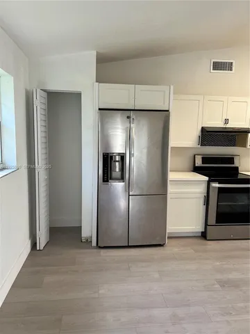 a metallic refrigerator freezer sitting in a kitchen