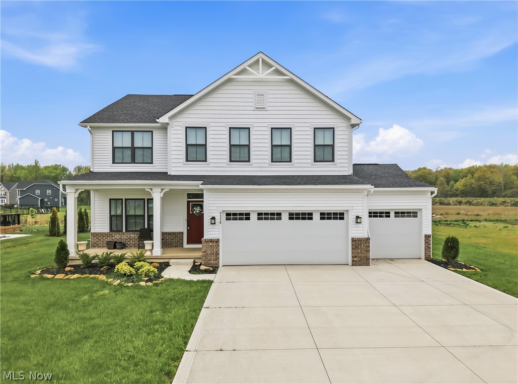 Two-story residence featuring white siding, a covered front porch, and a red entry door