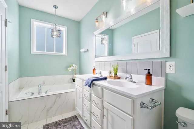 a bathroom with a sink vanity granite toilet and a bathtub
