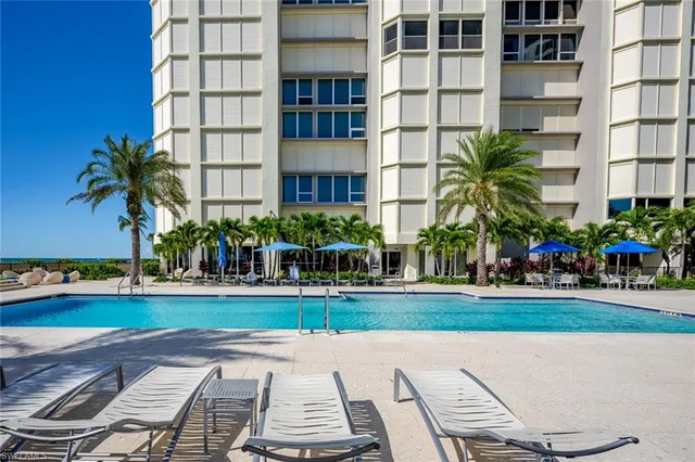 a living room with furniture and floor to ceiling windows