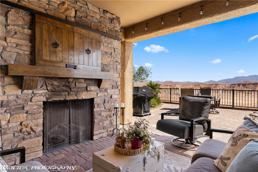 1262 Serenity Ridge Court Mesquite, NV 89034 - Photo 20 of 74 View of patio / terrace with an outdoor stone fireplace, a mountain view, and area for grilling