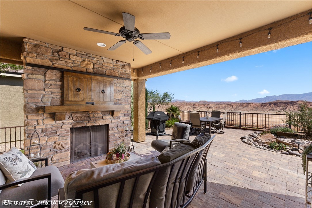 1262 Serenity Ridge Court Mesquite, NV 89034 - Photo 21 of 74 View of patio / terrace featuring an outdoor stone fireplace, outdoor lounge area, a mountain view, ceiling fan, and area for grilling