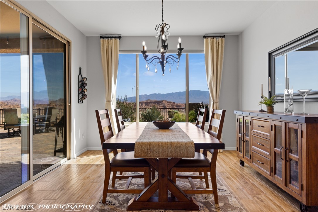 1262 Serenity Ridge Court Mesquite, NV 89034 - Photo 41 of 74 Dining space featuring a mountain view, light wood-type flooring, a chandelier, and plenty of natural light
