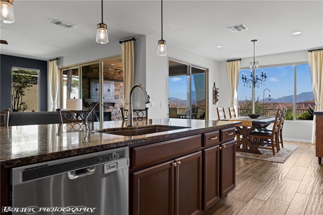 1262 Serenity Ridge Court Mesquite, NV 89034 - Photo 45 of 74 Kitchen featuring a mountain view, stainless steel dishwasher, dark stone counters, and a chandelier