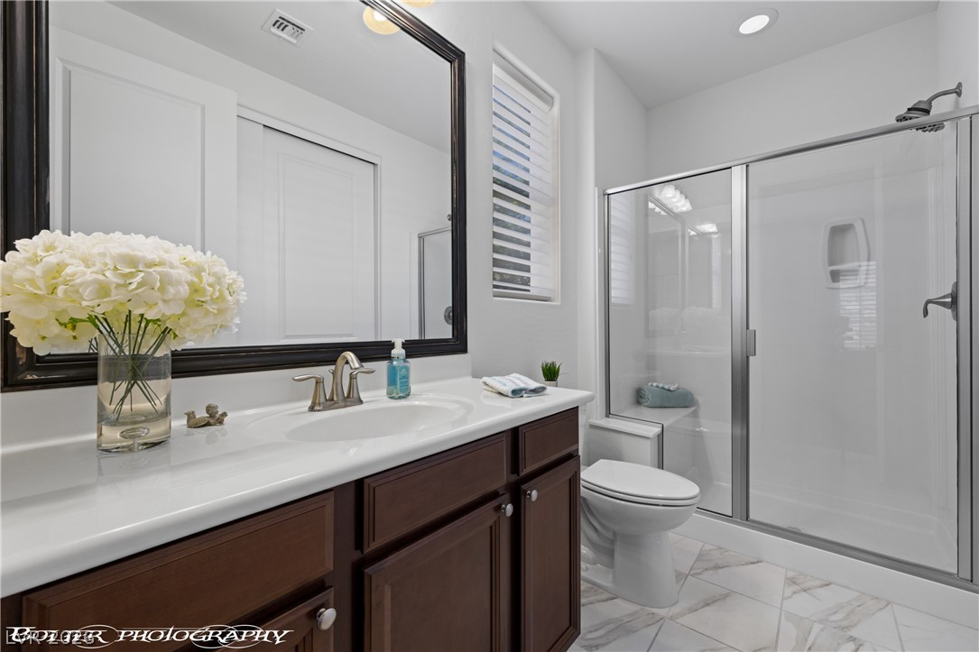 1262 Serenity Ridge Court Mesquite, NV 89034 - Photo 63 of 74 Bathroom with vanity, a shower stall, recessed lighting, and light marble finish floors