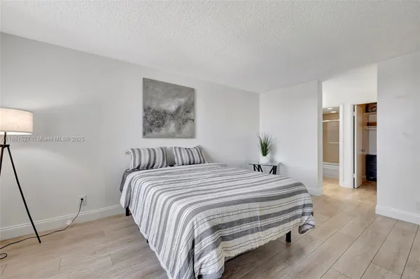 a bedroom with a bed and a potted plant
