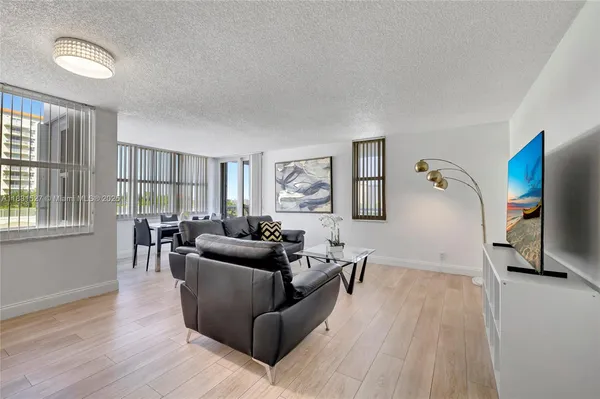a living room with furniture and a painting on the wall