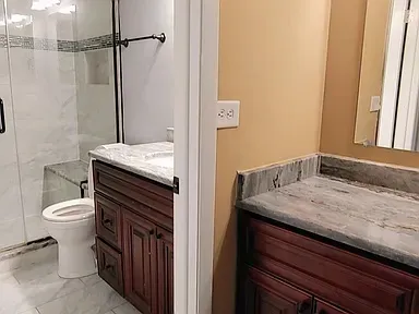 a bathroom with a sink a toilet a mirror and shower