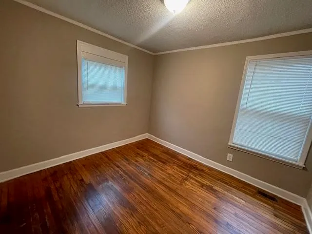 a view of a room with wooden floor and small window