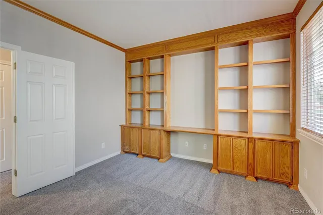 a view of an empty room with a fireplace and a window