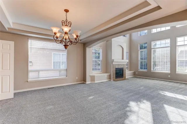 a view of a livingroom with a chandelier fan and windows