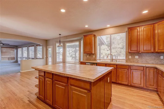 a kitchen with stainless steel appliances granite countertop wooden cabinets a sink and a large window