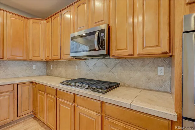 a kitchen with wooden cabinets and a stove top oven