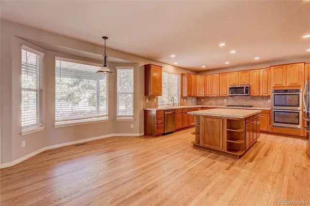 a kitchen with stainless steel appliances granite countertop a stove sink and refrigerator