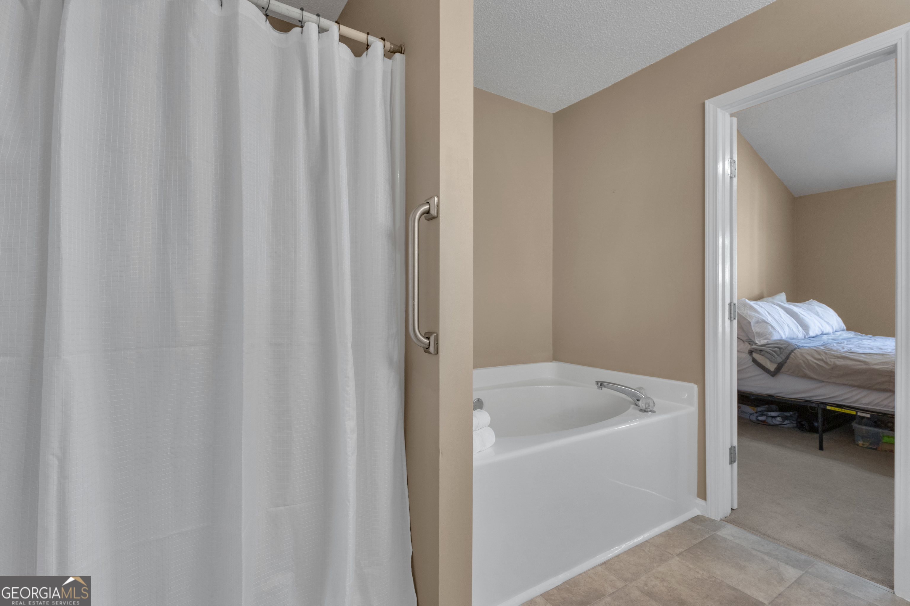 918 Scarletts Walk Locust Grove, GA 30248 - Photo 16 of 46 a bathroom with a tub and curtain