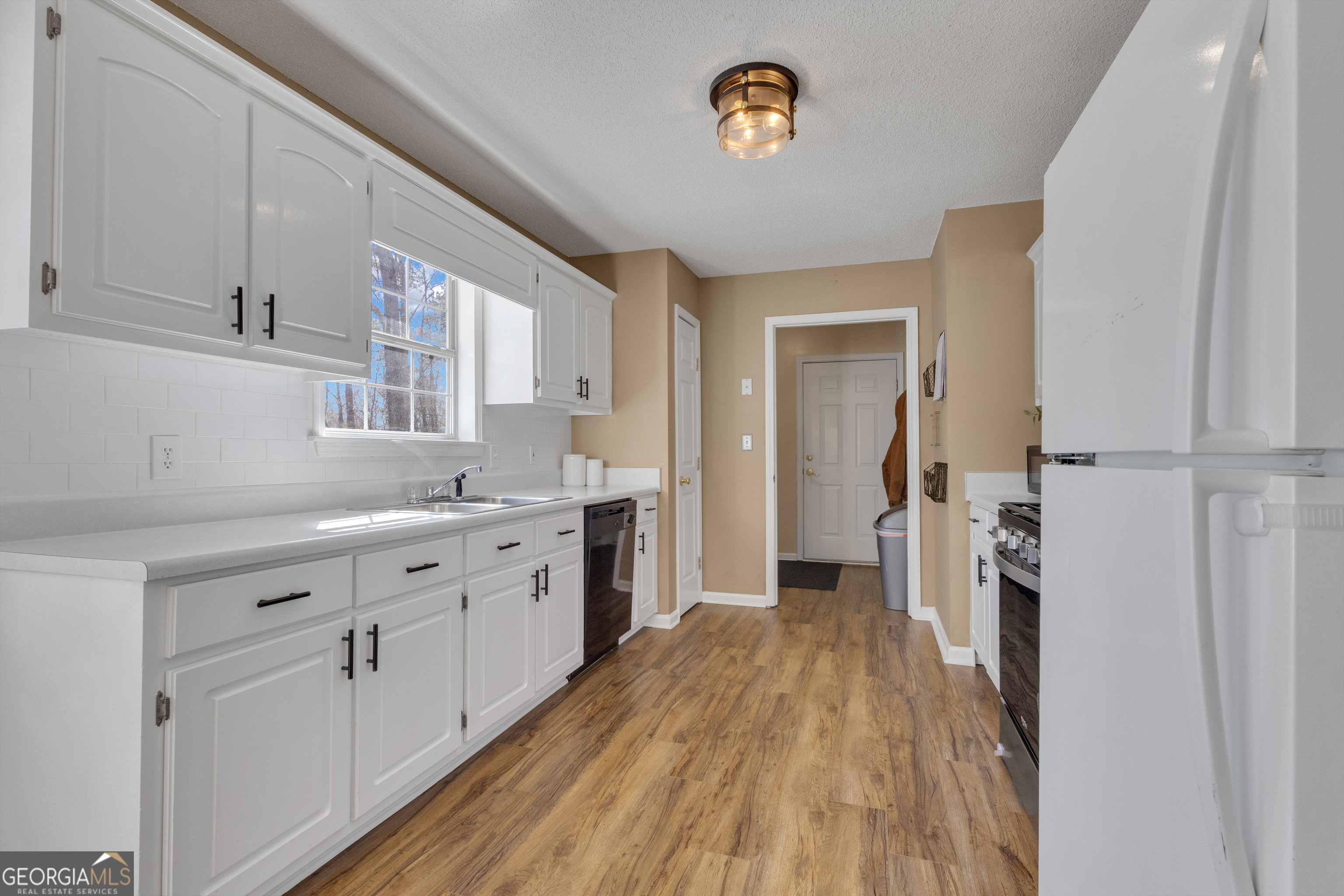 918 Scarletts Walk Locust Grove, GA 30248 - Photo 24 of 46 a kitchen with a sink a refrigerator and a stove