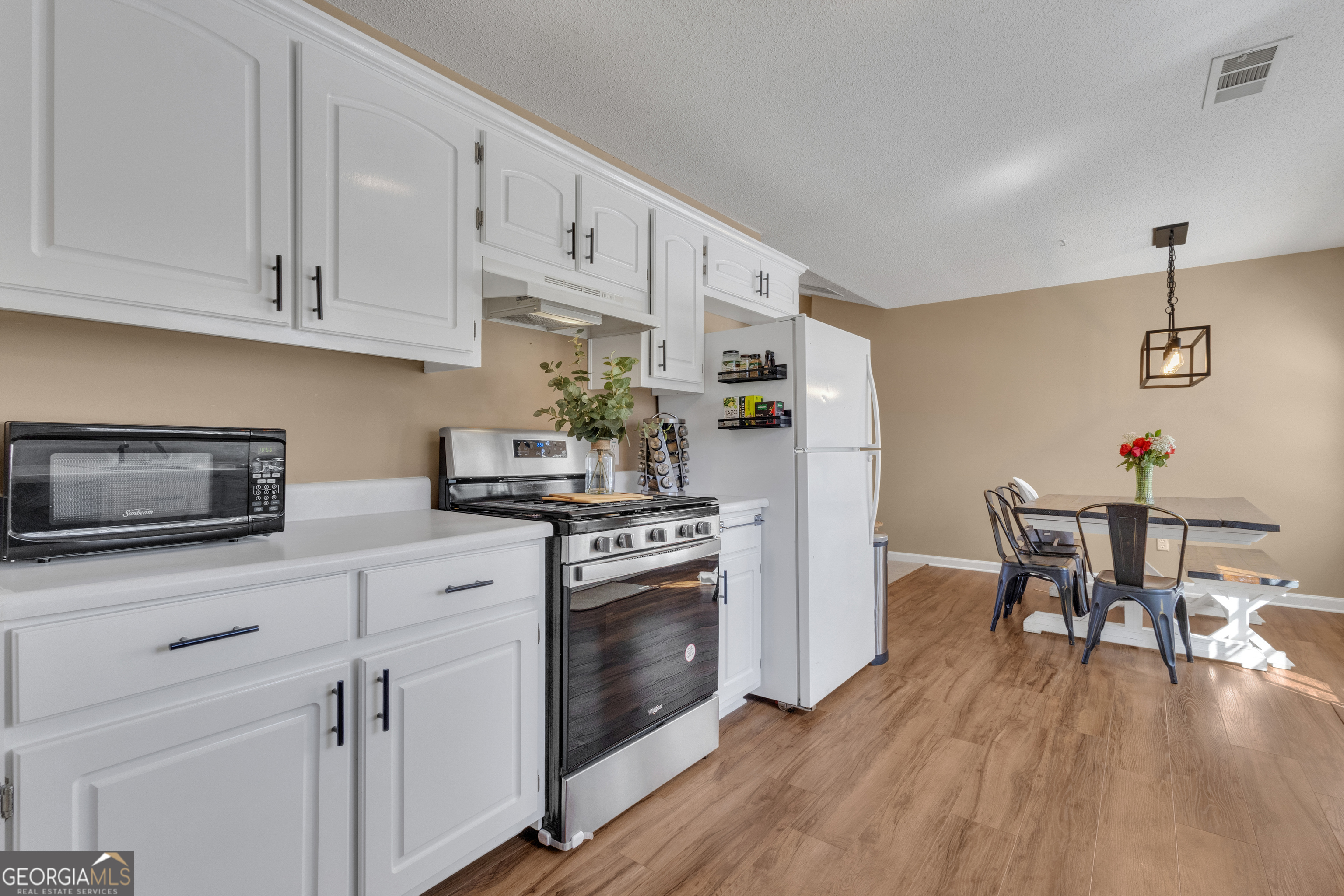 918 Scarletts Walk Locust Grove, GA 30248 - Photo 25 of 46 a kitchen with granite countertop a stove a sink dishwasher and a refrigerator with wooden floor