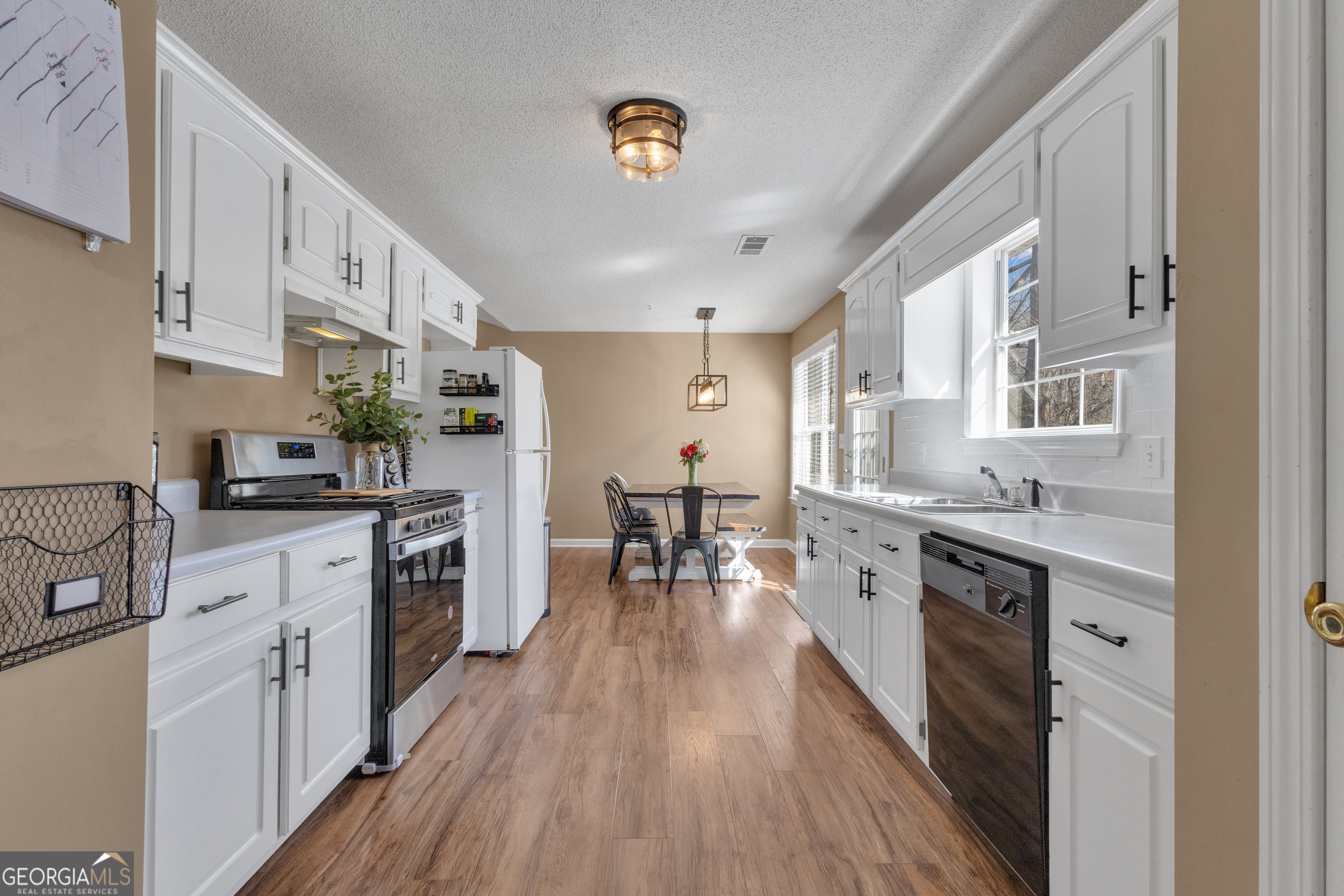 918 Scarletts Walk Locust Grove, GA 30248 - Photo 26 of 46 a kitchen with stainless steel appliances granite countertop lots of counter top space and wooden floors