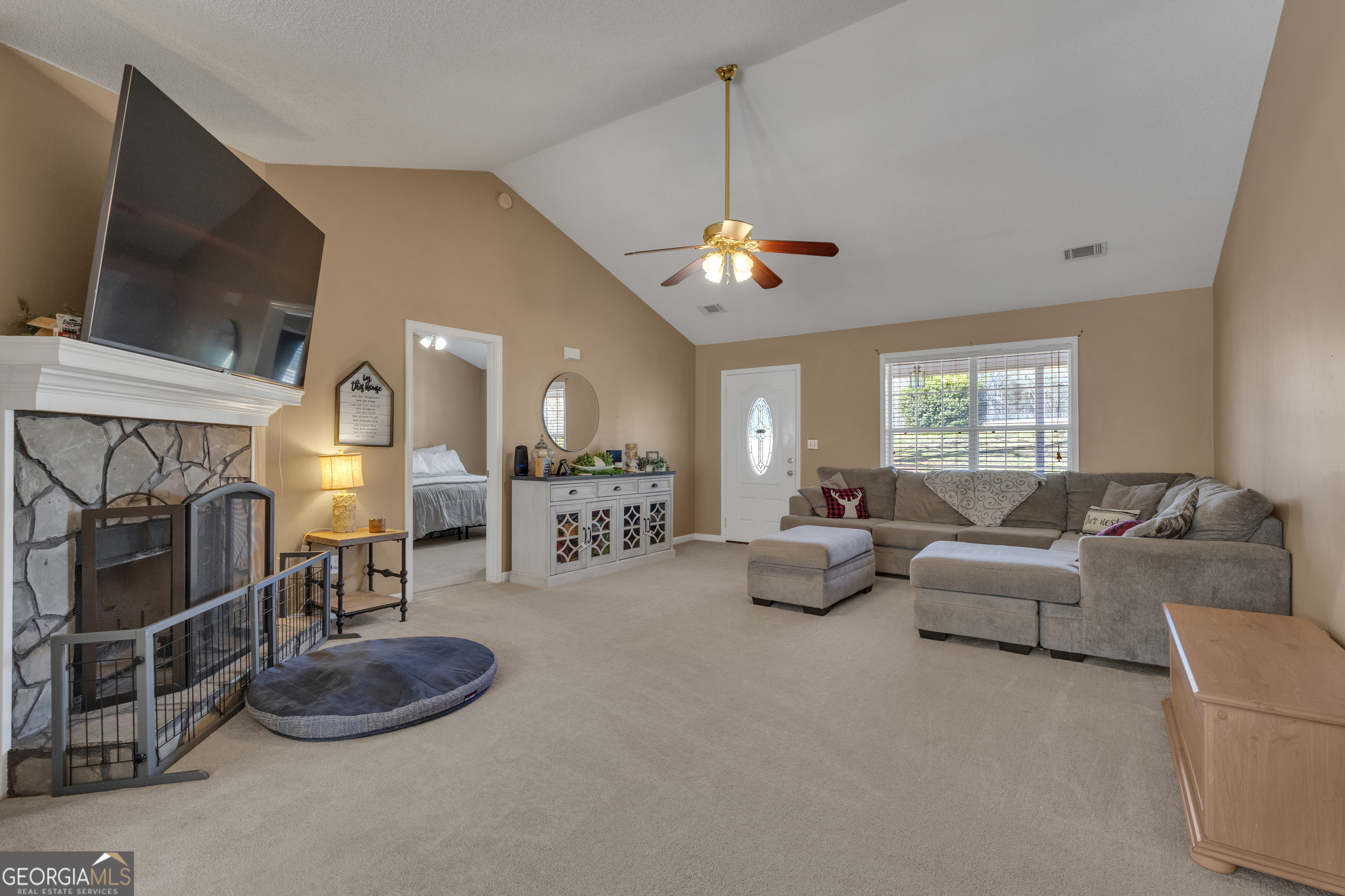 918 Scarletts Walk Locust Grove, GA 30248 - Photo 9 of 46 a living room with furniture a chandelier and a flat screen tv