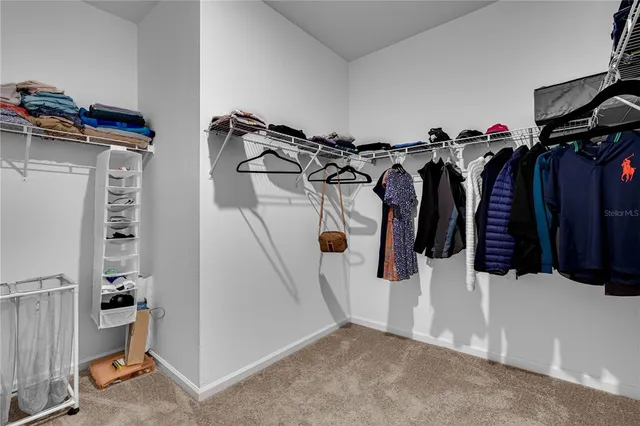 a view of walk in closet with clothes and shoes