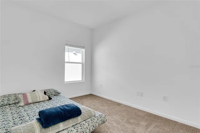 a bedroom with a large bed and a window