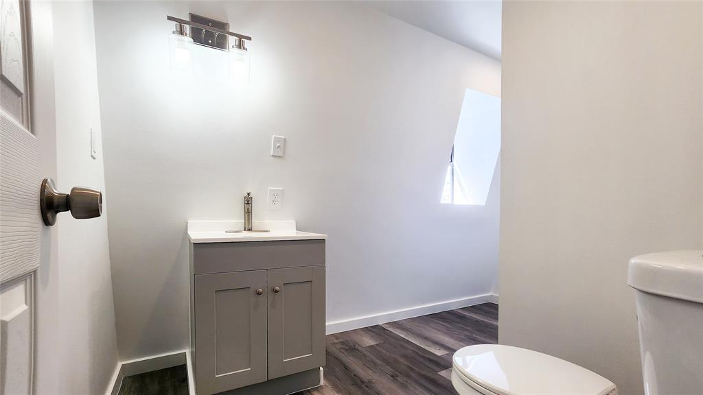 401 East Pierce Street Winters, TX 79567 - Photo 14 of 25 a bathroom with a granite countertop toilet sink and mirror