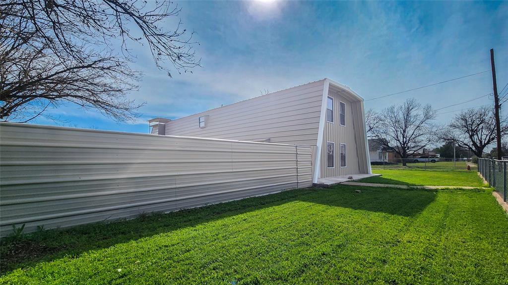 401 East Pierce Street Winters, TX 79567 - Photo 2 of 25 a view of a backyard with plants and large trees