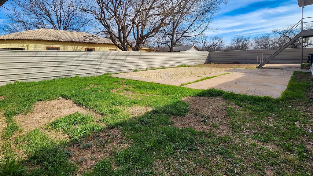 401 East Pierce Street Winters, TX 79567 - Photo 24 of 25 a view of a yard with an umbrella and a fire pit