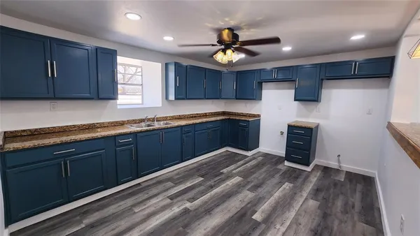 a kitchen with granite countertop a sink cabinets stainless steel appliances and a counter top space