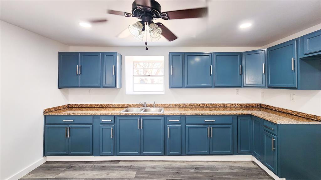 401 East Pierce Street Winters, TX 79567 - Photo 5 of 25 a kitchen with granite countertop wood cabinets and white appliances