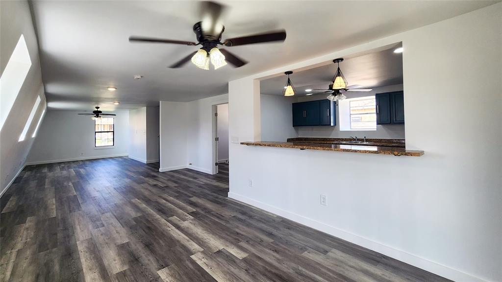 401 East Pierce Street Winters, TX 79567 - Photo 8 of 25 a view of kitchen and empty room with wooden floor