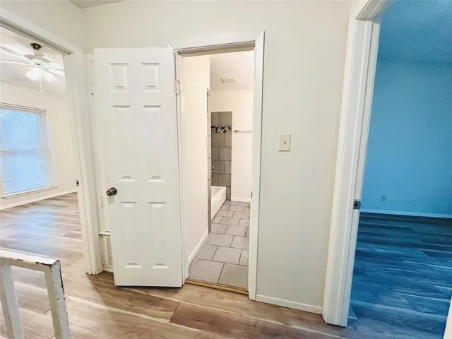 a view of a hallway with wooden floor and staircase