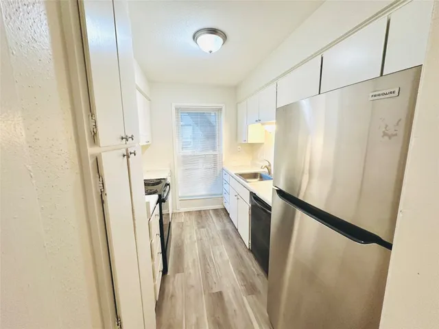 a kitchen with a refrigerator a sink and cabinets