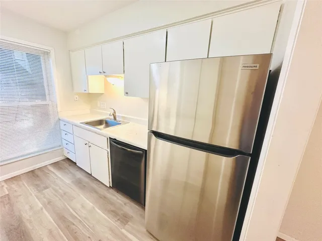 a kitchen with a refrigerator a sink and cabinets