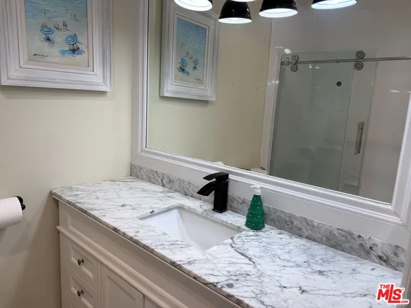 a bathroom with a granite countertop toilet and a sink